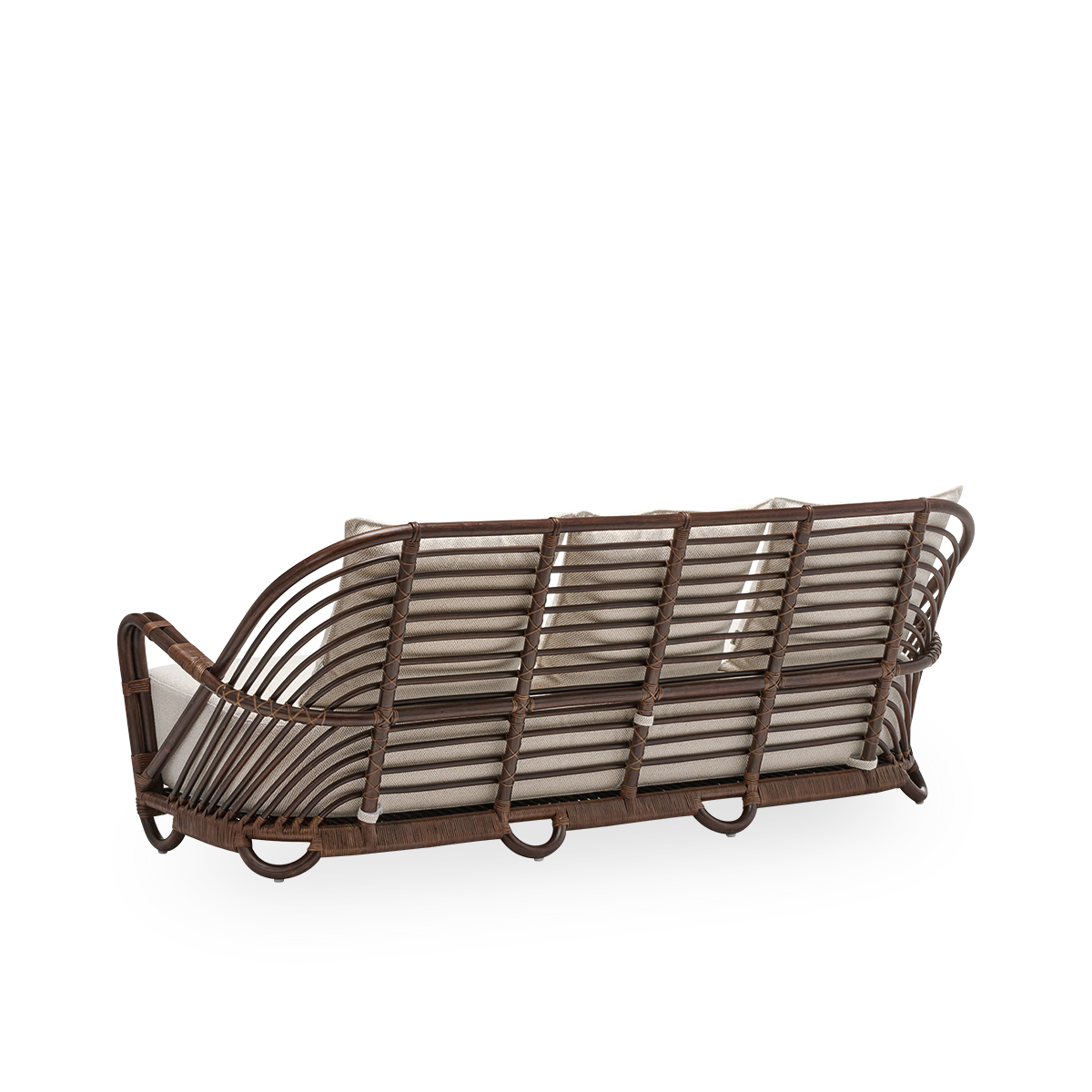 Back side view of the Charlottenborg 3-seater sofa with seat and back cushions, in brown rattan. Originally designed by Arne Jacobsen in 1936, its gracefully curved backrest flows seamlessly into the armrests. Handcrafted in rattan.