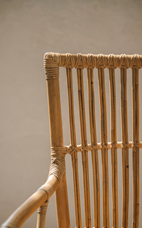 This is a close-up image of Piano Dining Chair in antique rattan. Slatted backrest with hand-wrapped rattan joints.