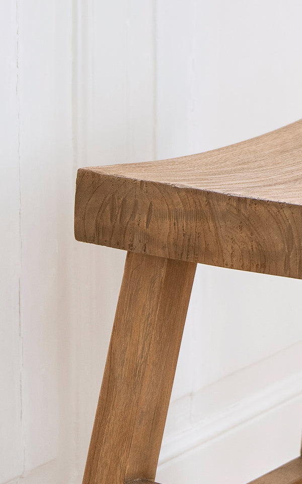 This is a close-up image of Charles Stool in teak indoor.