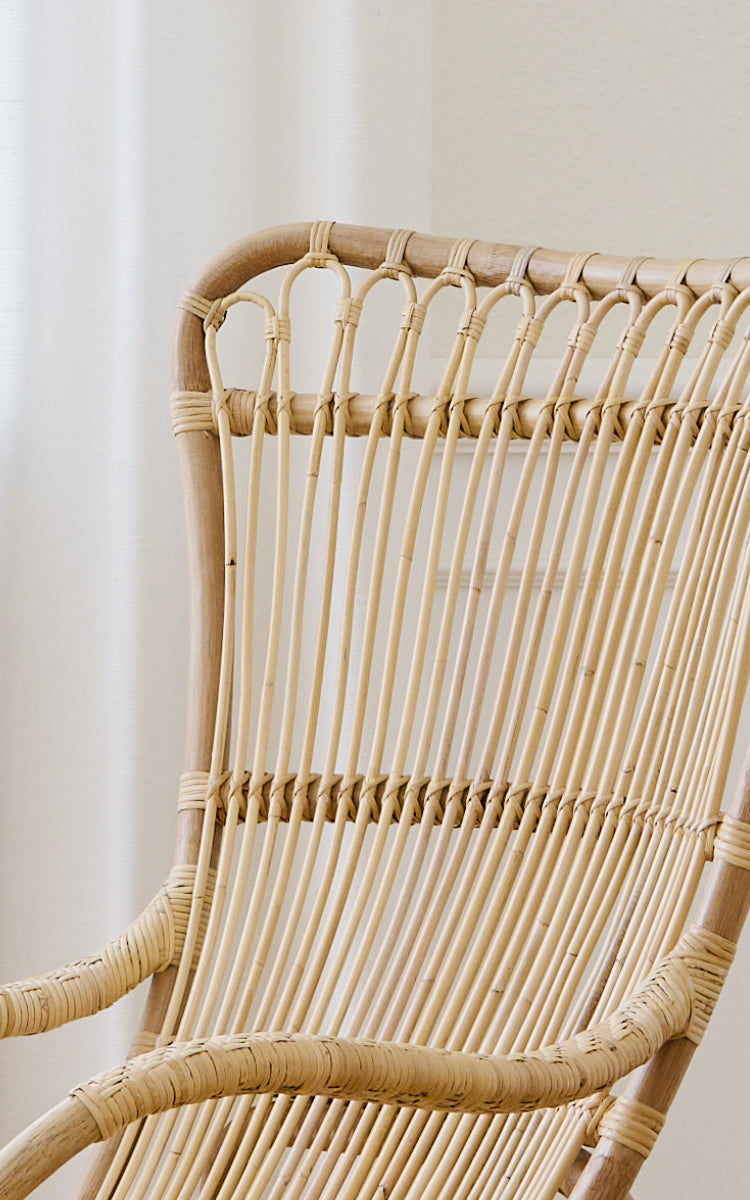 This is a close-up image of Monet Lounge Chair in natural rattan. Detail of the looped arches and smooth vertical rattan rods.