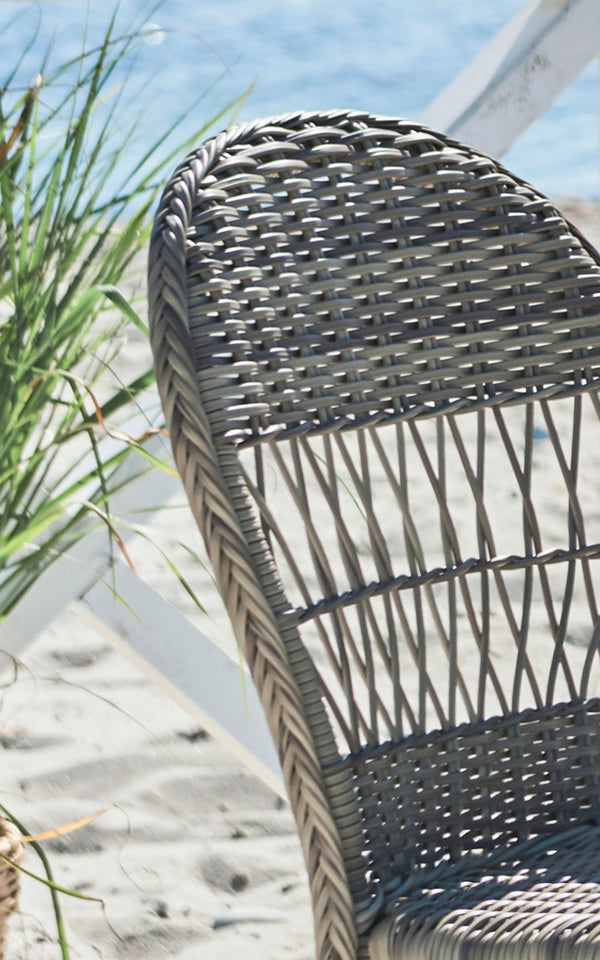 This is a close-up image of Ofelia Exterior Chair in antique grey artfibre aluminium. Detail of the rounded woven back and frame.