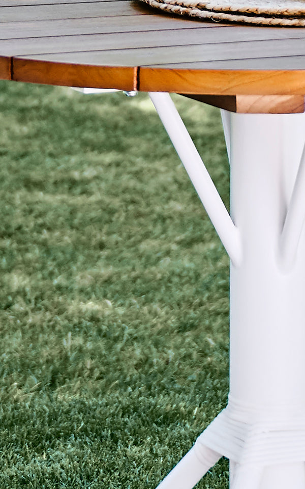 This is a close-up image of Nicole Cafe Table in white aluminium frame white ArtFibre. Detail of the teak top and white base.