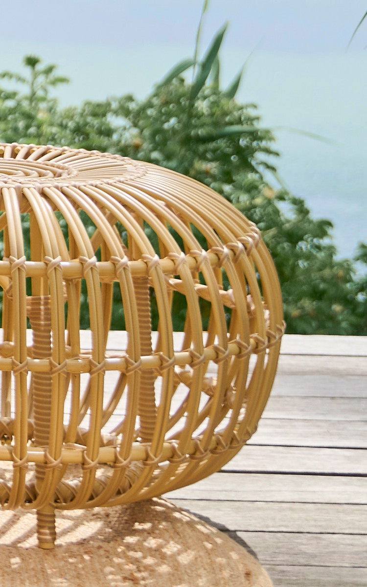 This is a close-up image of FA-E16-NU Ottoman Exterior in natural aluminium artfibre. Detail of the woven ArtFibre ottoman with curved ribs on a deck.