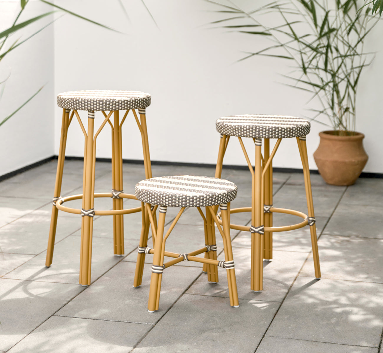 This is a lifestyle image of Simone Exterior Bar Stool in almond aluminium frame striped cappuccino ivory artfibre.