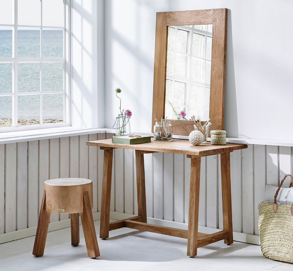 This is a lifestyle image of Roger Stool in teak indoor. Placed at a wooden desk with lamp and plant in a bright herringbone-floor study.