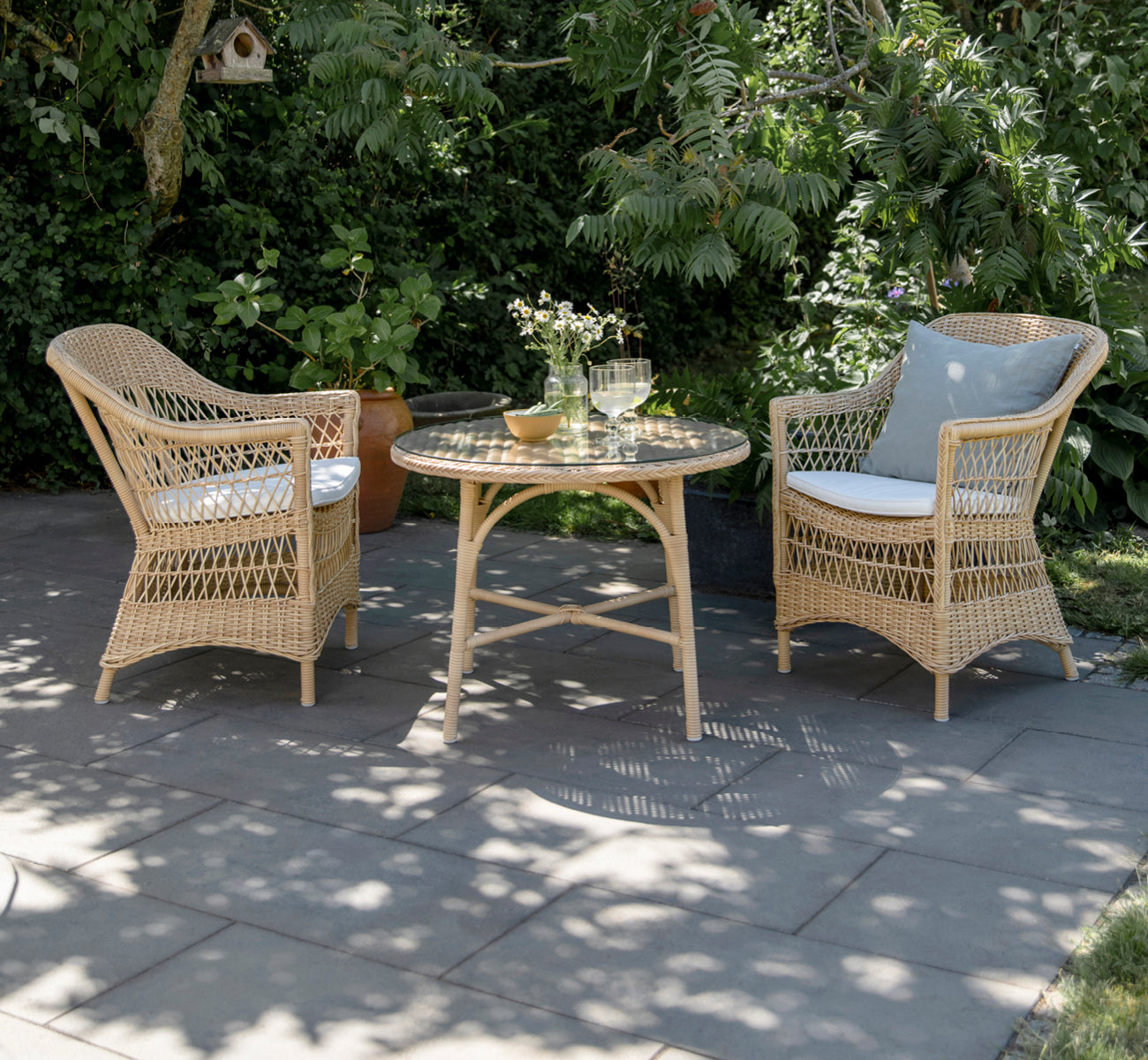 This is a lifestyle image of Victoria Exterior Coffee Table Ø80 cm in natural artfibre aluminium. Styled in a bright interior setting.