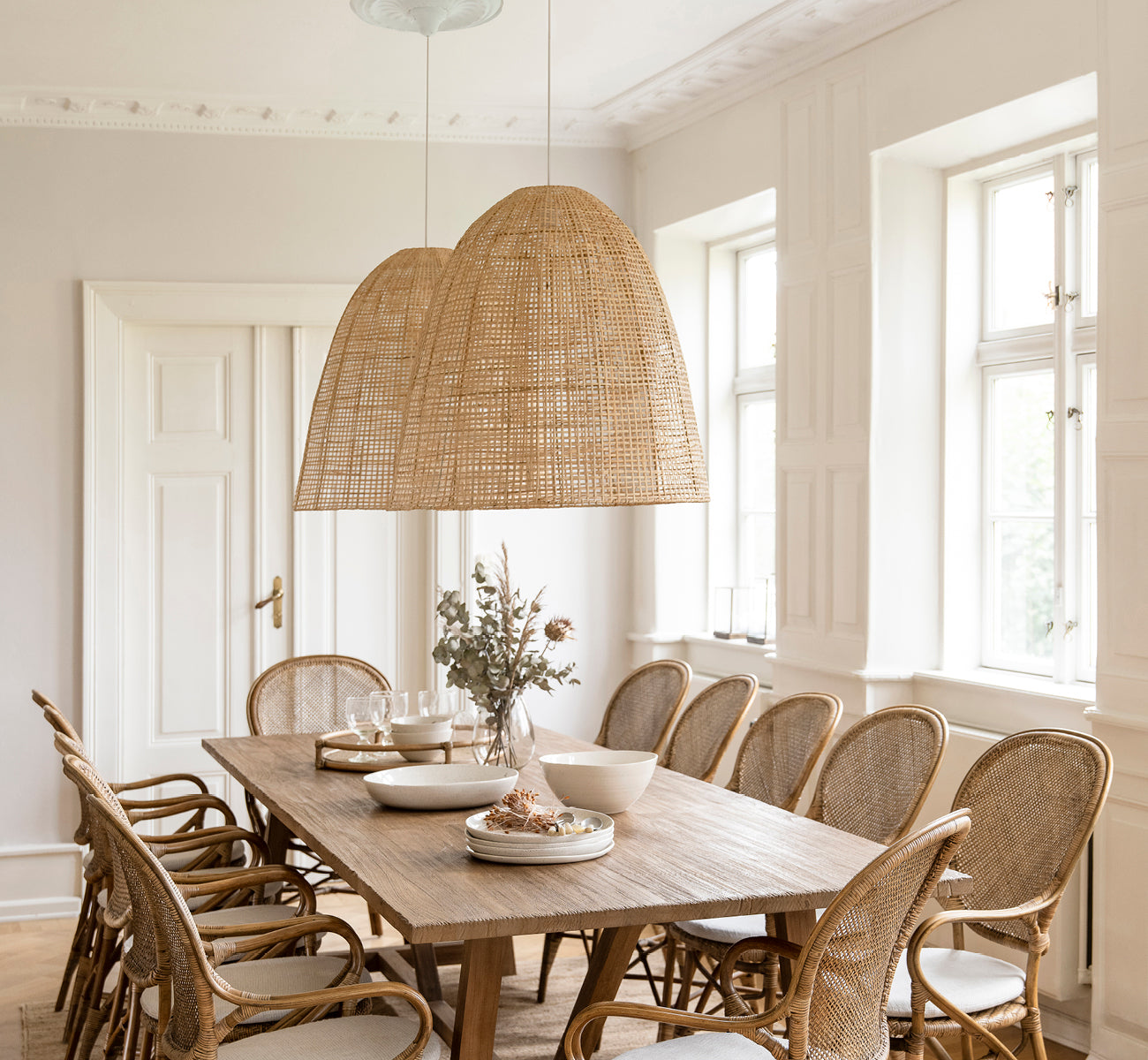 This is a lifestyle image of Showroom Lampshade in natural core weave artfibre & aluminium. Hanging over a set dining table in a bright room.