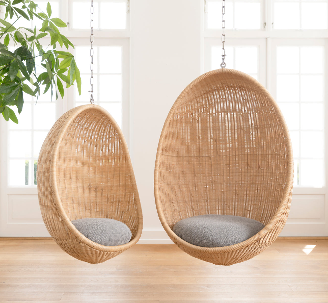 This is a lifestyle image of Hanging Egg Chair Junior in natural core weave Rattan frame, in an elegant classical interior with ornate golden.