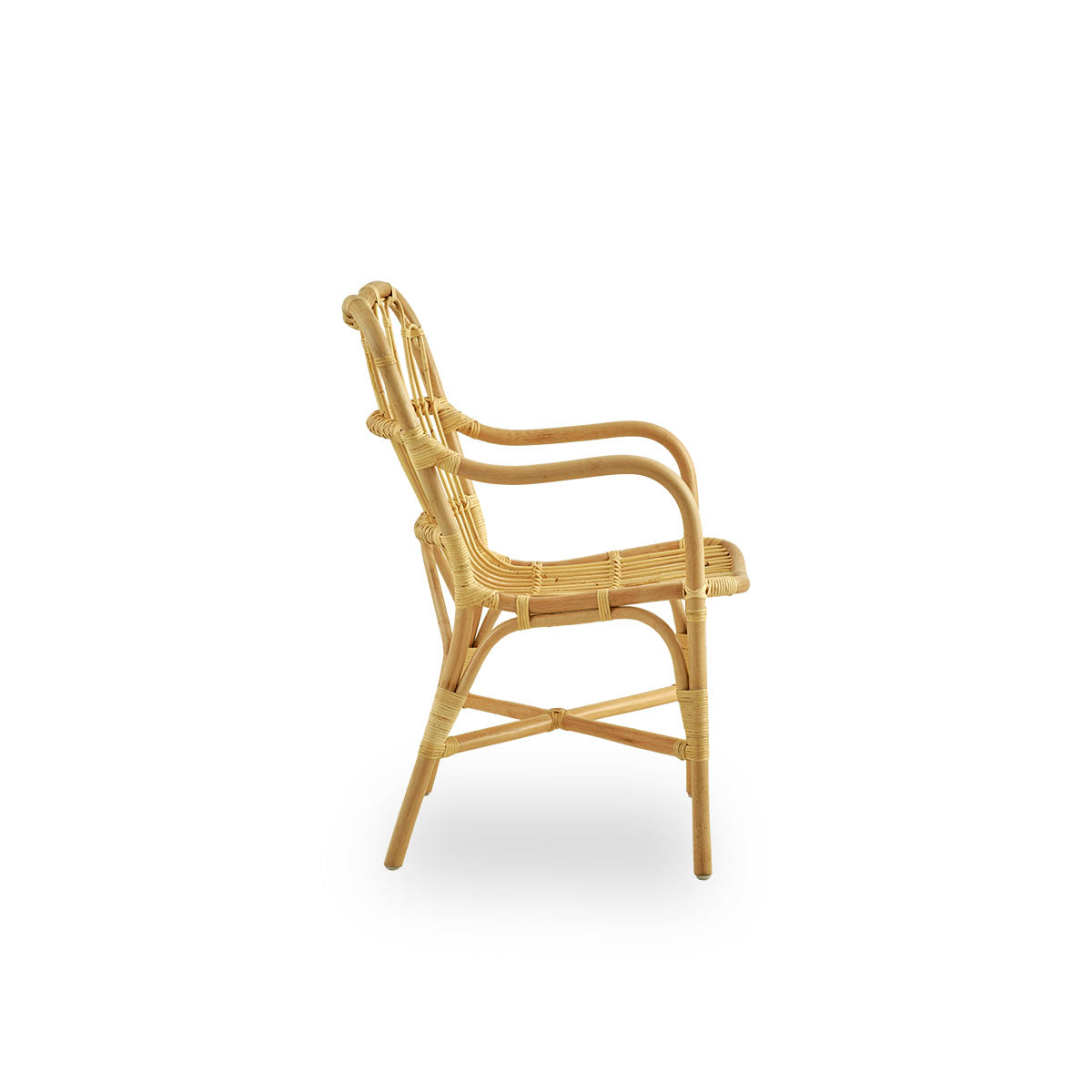 Plain side view of Margret dining chair with high wide backrest and curved armrests. Handcrafted from high-quality Indonesian rattan.