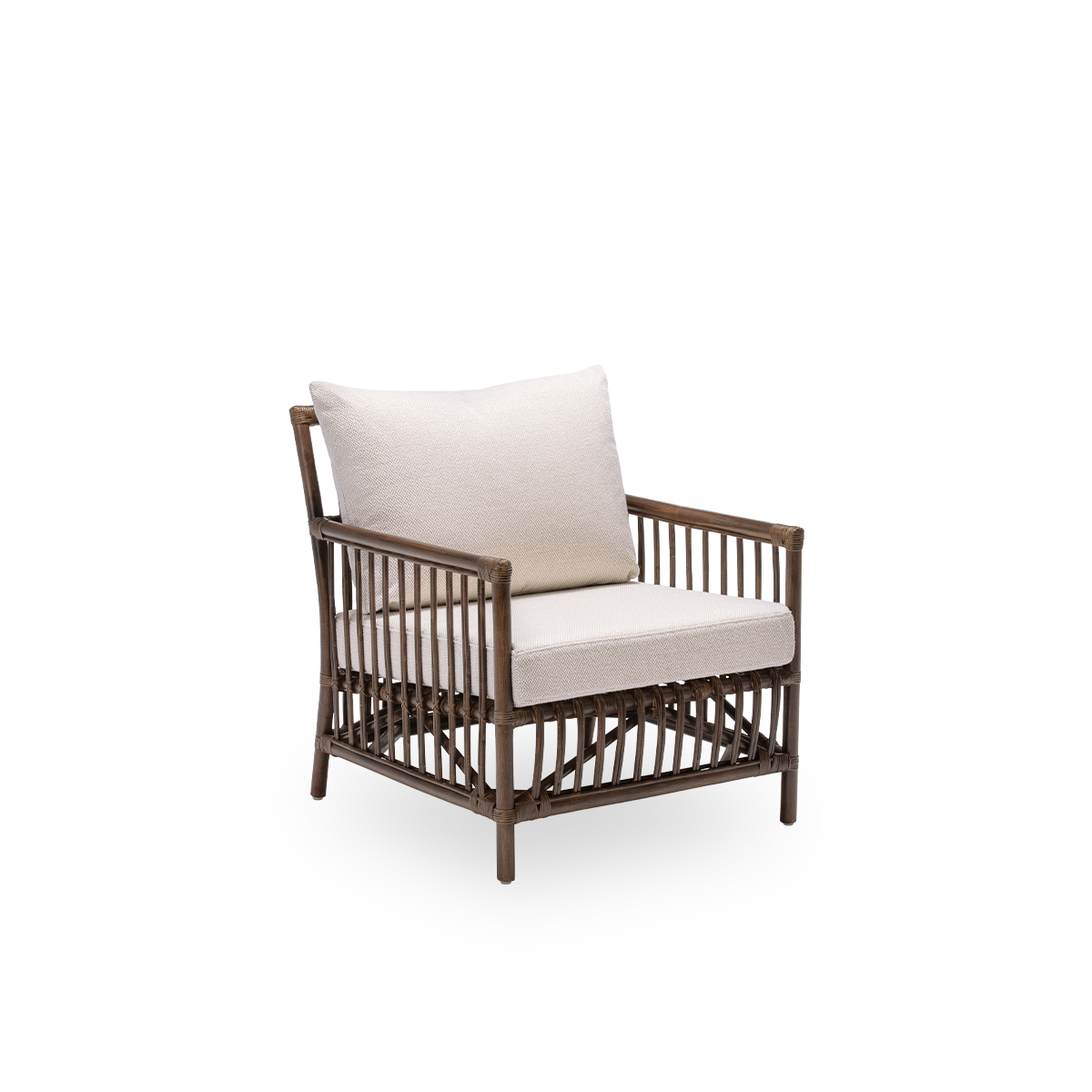 Side view of the Caroline lounge chair with seat and back cushions, in brown rattan. A simple and elegant Danish design whose detailed windings make it a quiet element in the room. Handcrafted from high-quality Indonesian rattan.