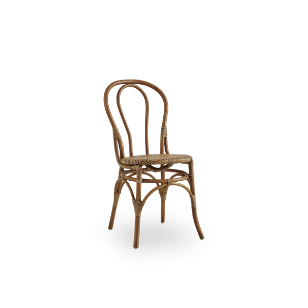Side view of Lulu dining chair in Antique brown color, handcrafted from high-quality Indonesian rattan. Lightweight, elegant design with round simple backrest.
