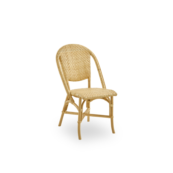 Side view of Alanis dining chair in high quality natural rattan, featuring elegant curves and detailed weaving. 