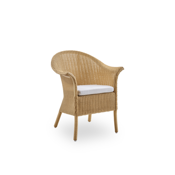 Side view of Classic dining chair, a fully woven wicker dining chair handcrafted in Lloyd Loom material. The Classic chair features armrests and a high backrest for extra comfort and support.