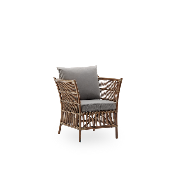 Side view of Donatello wicker lounge chair in Antique brown color. The lounge chair has a boxy design with strict lines handcrafted from high-quality Indonesian rattan.