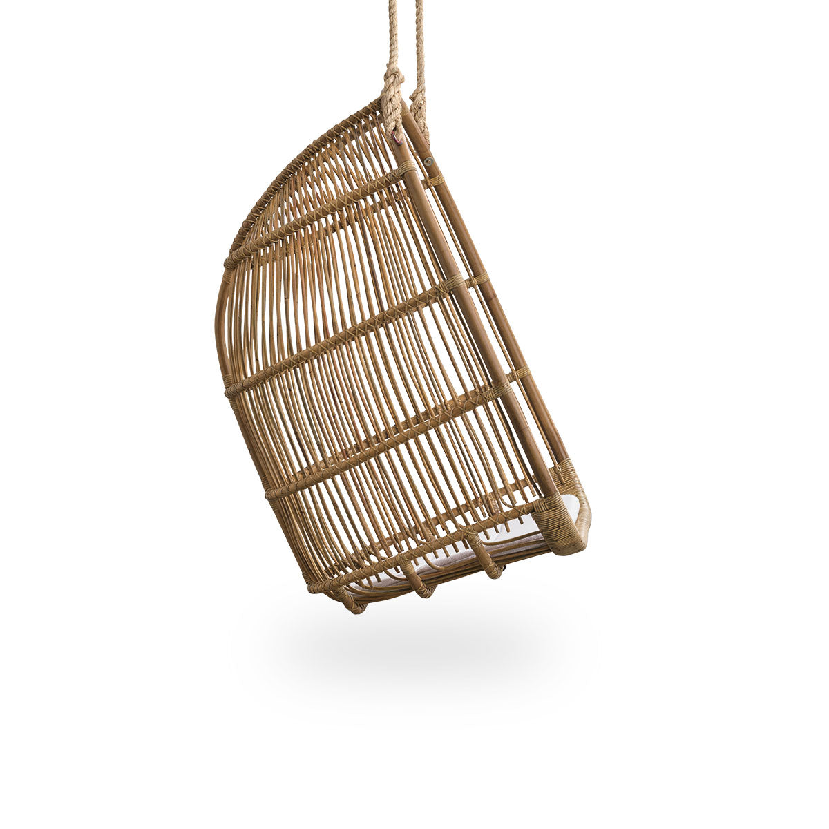 Plain side view of Renoir hanging chair in Antique brown color handcrafted in high quality rattan. Soft, embracing shape suspended with strong rope.