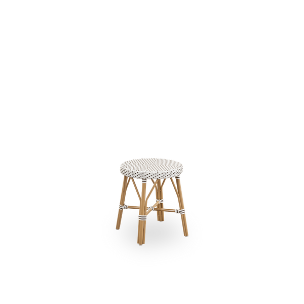 Side view of Simone outdoor stool height 52 cm. Aluminium frame in Almond color with footrest, with fully woven round seat handcrafted in ArtFibre in white with brown dots pattern. Stackable stool.