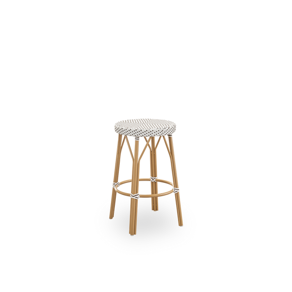 Side view of Simone outdoor counterstool height 68 cm. Aluminium frame in Almond color with footrest, with fully woven round seat handcrafted in ArtFibre in white with brown dots pattern. Stackable counterstool.