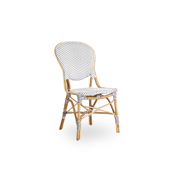 Side view of Isabell dining chair. Rattan frame with seat and backrest made in white ArtFibre with brown dots. Inspired by 1950s bistro design.