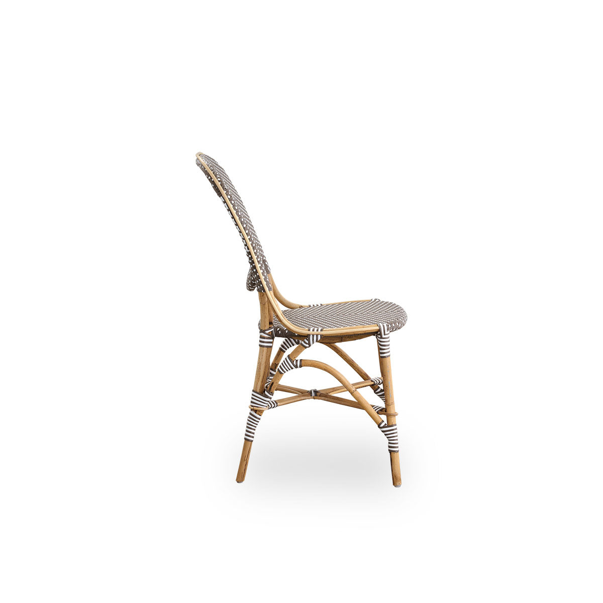 Plain side view of Isabell dining chair. Rattan frame with seat and backrest made in brown ArtFibre with white dots. Inspired by 1950s bistro design.