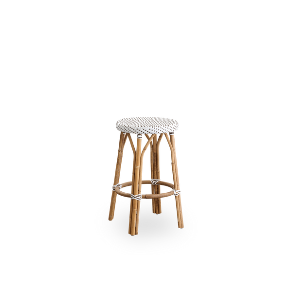 Side view of Simone counterstool height 68 cm. Rattan frame with footrest, with fully woven round seat handcrafted in ArtFibre in white with brown dots pattern. Stackable counterstool.