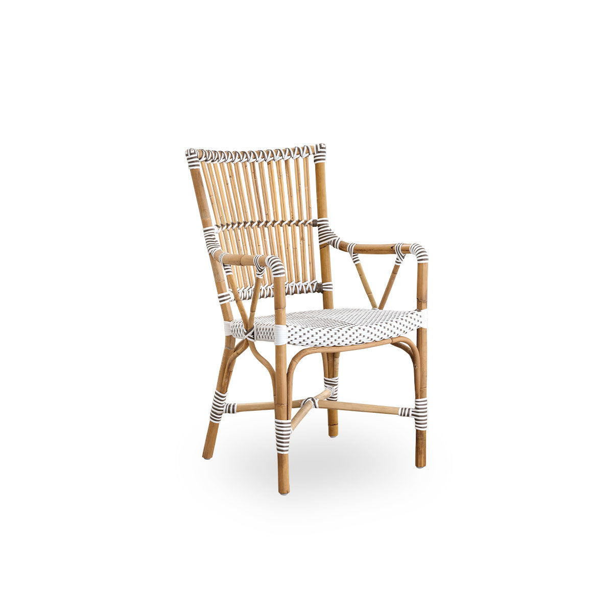 Side view of Monique dining armchair. Rattan frame with seat woven with ArtFibre in white with brown dots. Inspired by 1950s bistro design.
