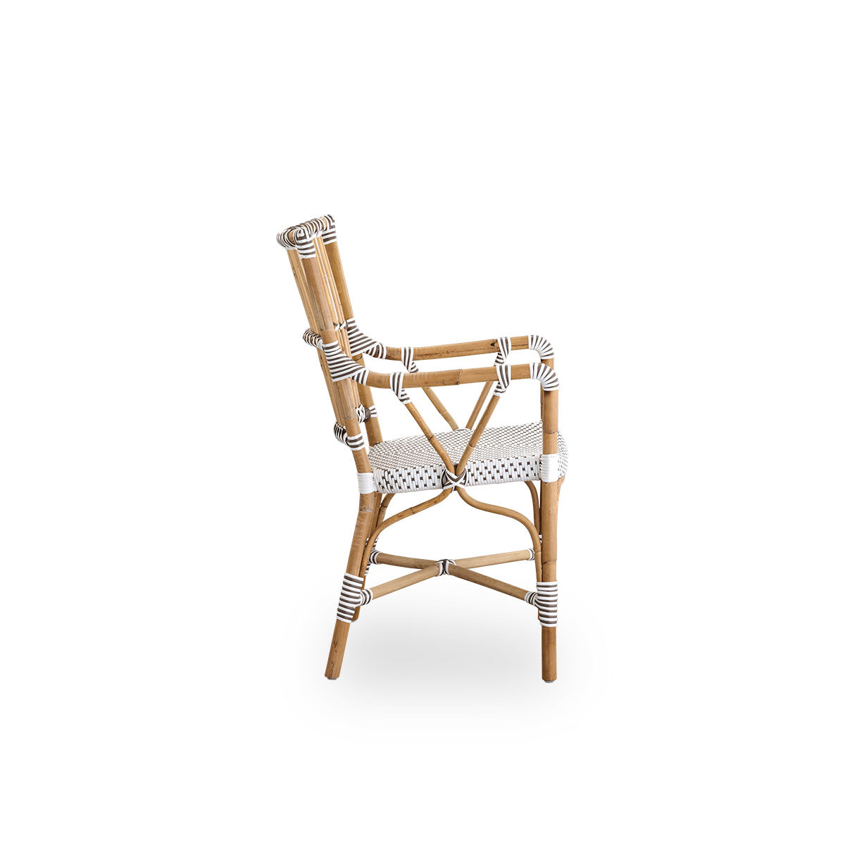 Plain side view of Monique dining armchair. Rattan frame with seat woven with ArtFibre in white with brown dots. Inspired by 1950s bistro design.