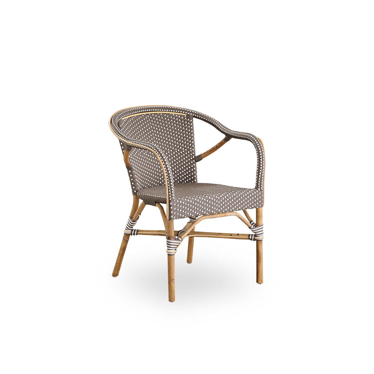 Side view of Madeleine dining armchair. Rattan frame with seat and backrest woven with ArtFibre in brown with white dots. Inspired by 1950s bistro design.