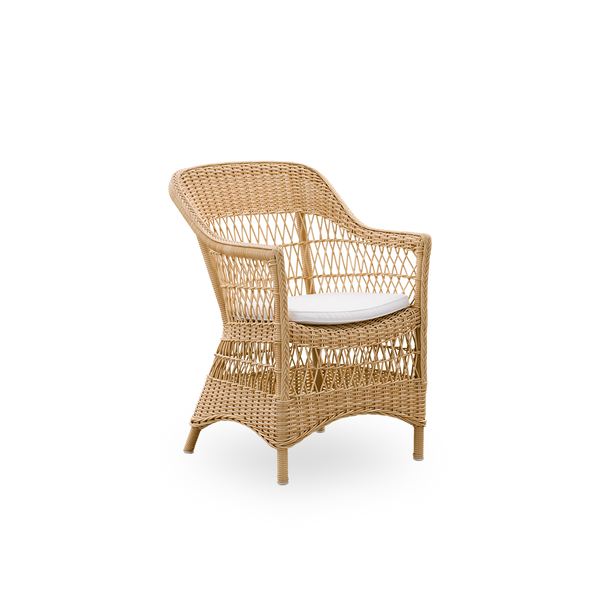 Side view of the Charlot Exterior dining chair in a natural color, a fully woven outdoor chair in British colonial style handcrafted from ArtFibre on durable aluminum frames.