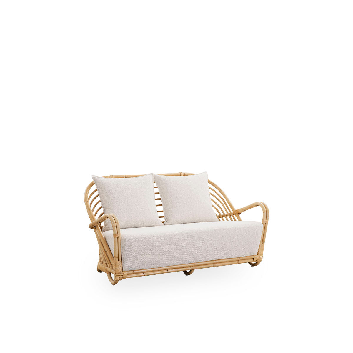 Side view of the Charlottenborg 2-seater Sofa in polished natural rattan, designed by Arne Jacobsen. The sofa features a curved back and armrests integrated into the base, handcrafted from high quality Indonesian rattan.