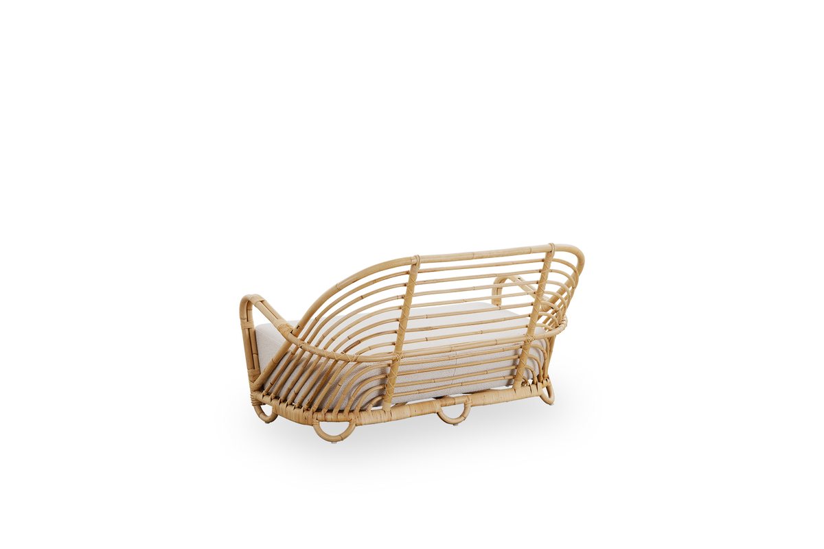 Back side view of the Charlottenborg 2-seater sofa in polished natural rattan, designed by Arne Jacobsen. The sofa features a curved back and armrests integrated into the base, handcrafted from high-quality Indonesian rattan.
