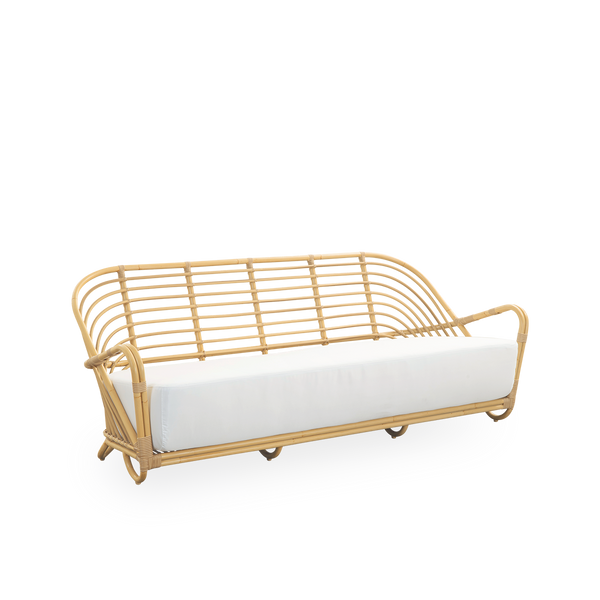 Side view of the Charlottenborg Exterior 3-seater sofa in rattan look, designed by Arne Jacobsen. The sofa features a curved back and armrests integrated into the base, handcrafted with an Alu-Rattan frame and woven ArtFibre details.
