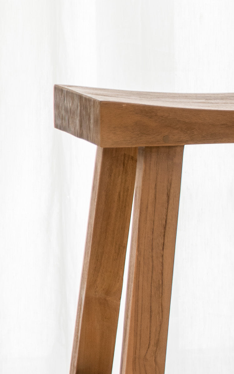 This is a close-up image of Charles Counter Stool in teak indoor.