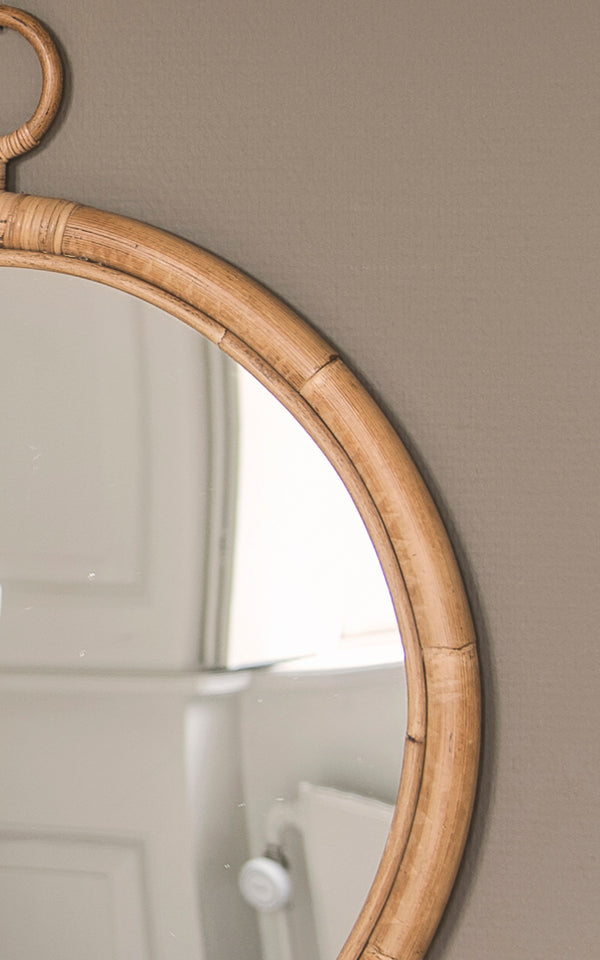 This is a close-up image of Ella Mirror O50cm in natural skin on rattan.