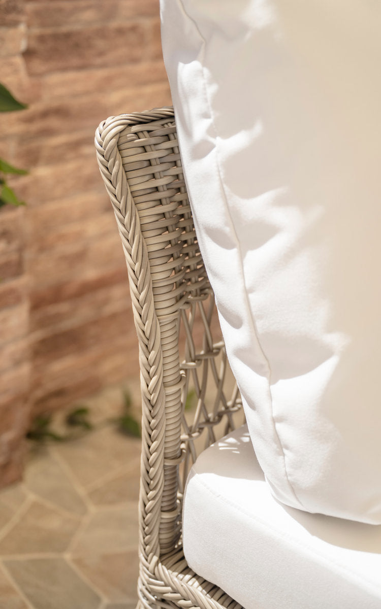 This is a close-up image of Mona Exterior Modular Sofa-Corner Module in antique grey artfibre aluminium. Woven armrest with white cushion.