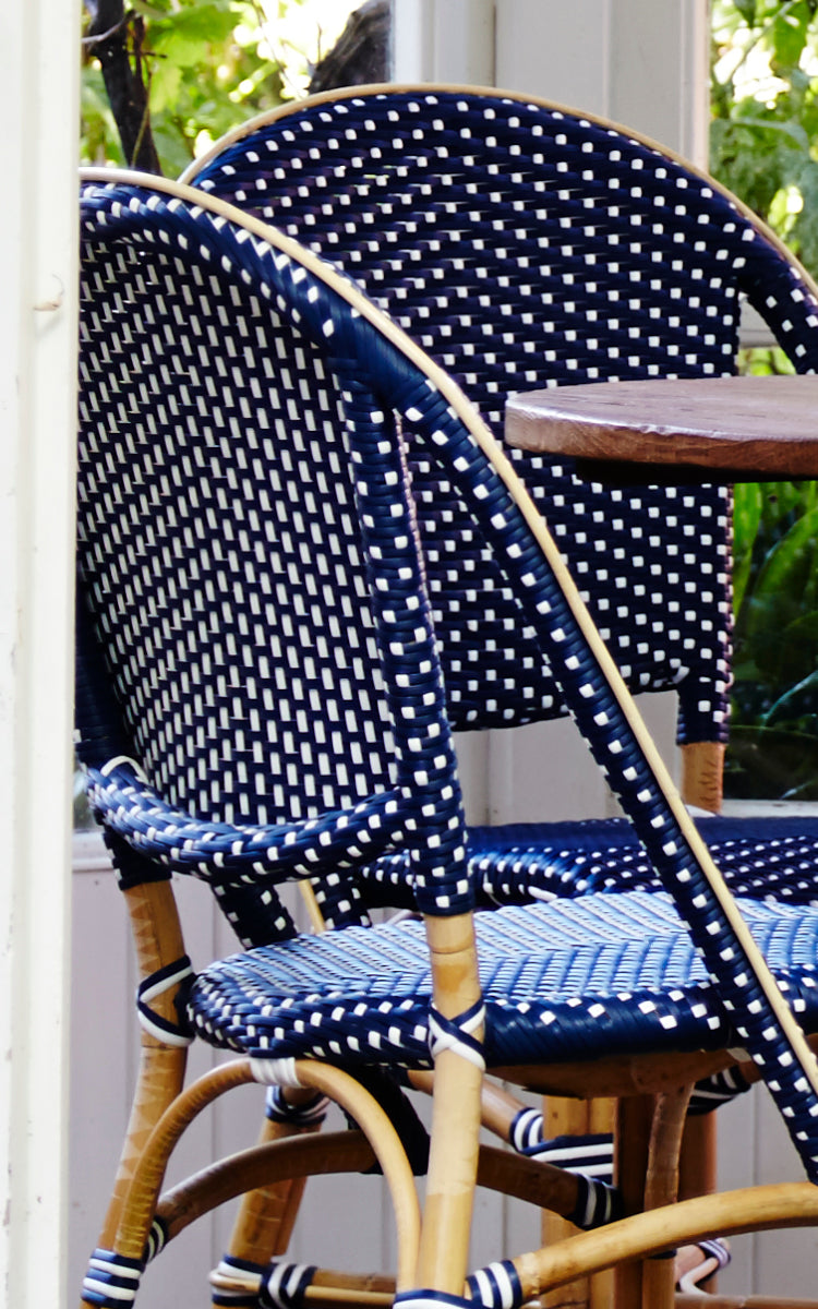 This is a close-up image of Sofie Dining Chair in navy blue w white dot artfibre skin on natual rattan frame.