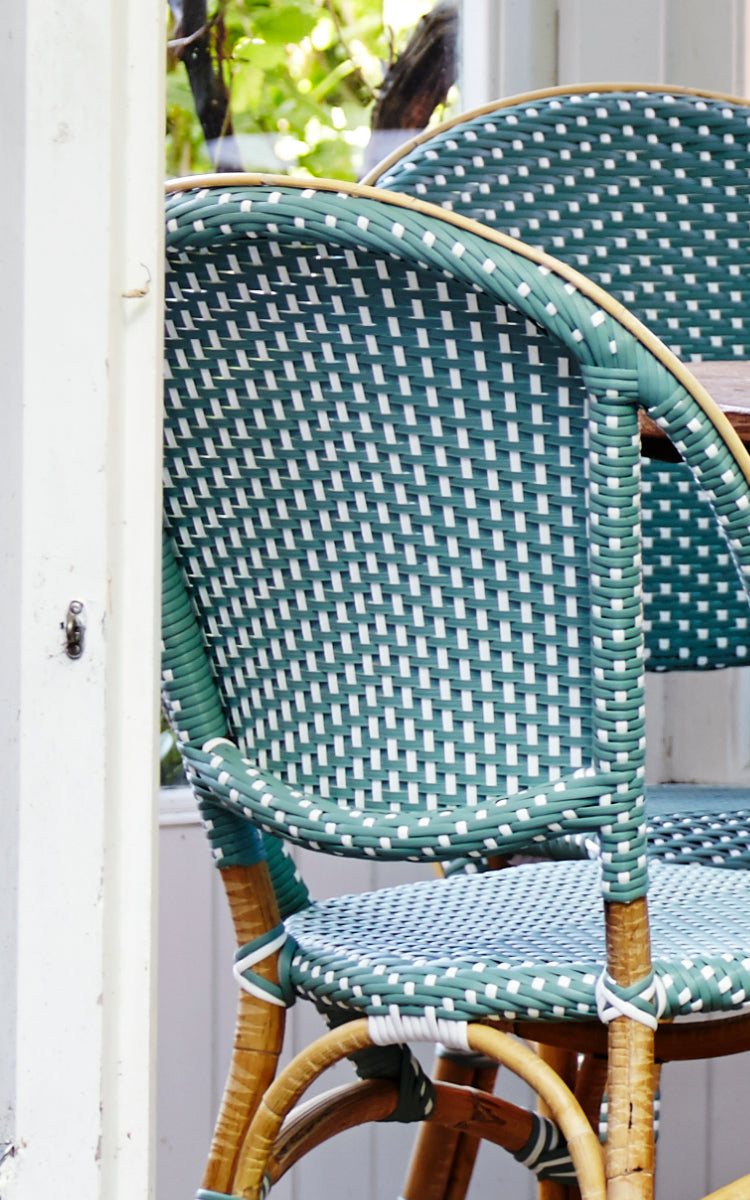 This is a close-up image of Sofie Dining Chair in salvie green w white dot artfibre skin on natual rattan frame.
