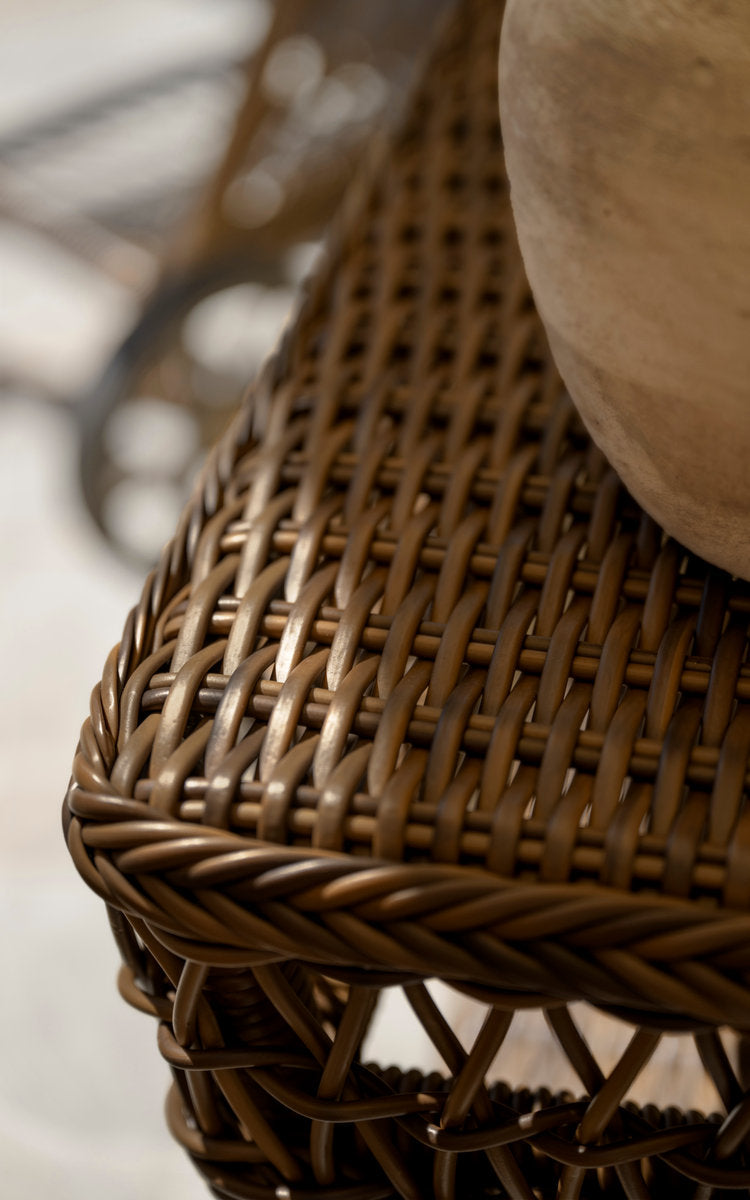 This is a close-up image of Susy Exterior Side Table in brown artfibre aluminum. Braided edge and dense weave.