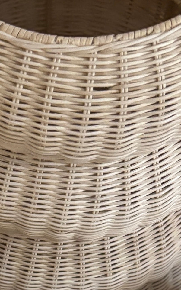 This is a close-up image of Mel Basket in natural core weave rattan frame. Detail of the tiered hourglass shape and tight weave.