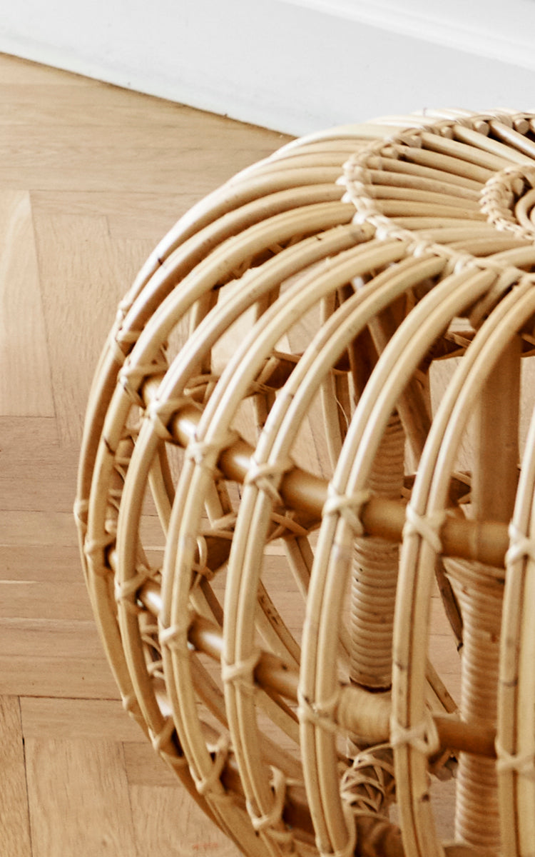 This is a close-up image of Ottoman Large in natural skin on rattan. Detail of the large natural rattan cage structure on parquet.
