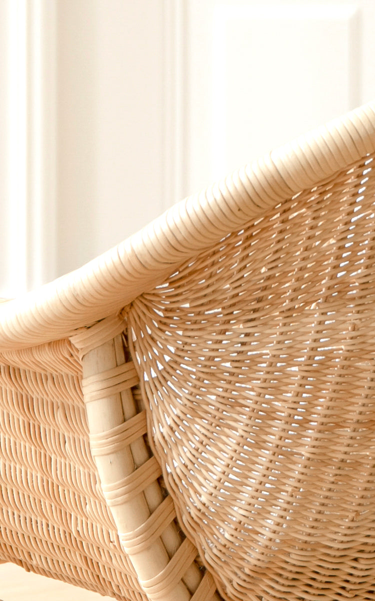 This is a close-up image of Madame Lounge Chair in natural core weave rattan frame. Fine woven rattan backrest detail with soft light.
