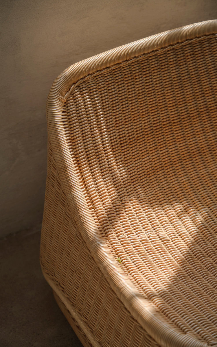 This is a close-up image of Chill Lounge Chair in natural core weave rattan frame. Woven seat shell with a smooth curved edge.