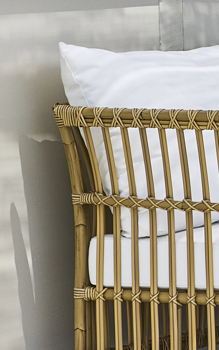 This is a close-up image of Maggie Sofa Corner Module in antique aluminium artfibre. Vertical slat frame with wrapped joints and white cushion.