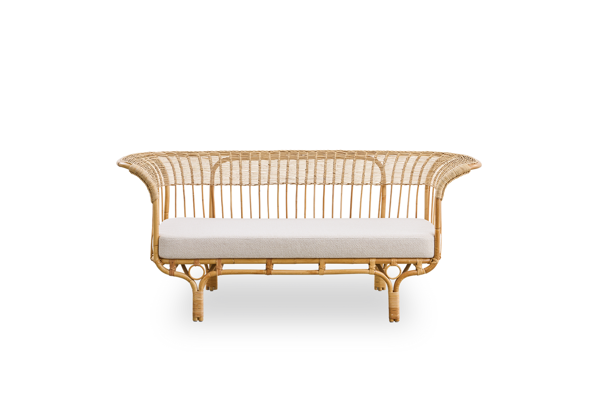 Front view of Belladonna sofa in natural rattan, designed by Franco Albini and Franca Helg. The sofa has an elegant expression with thin legs and a majestic seat with many detailed windings.