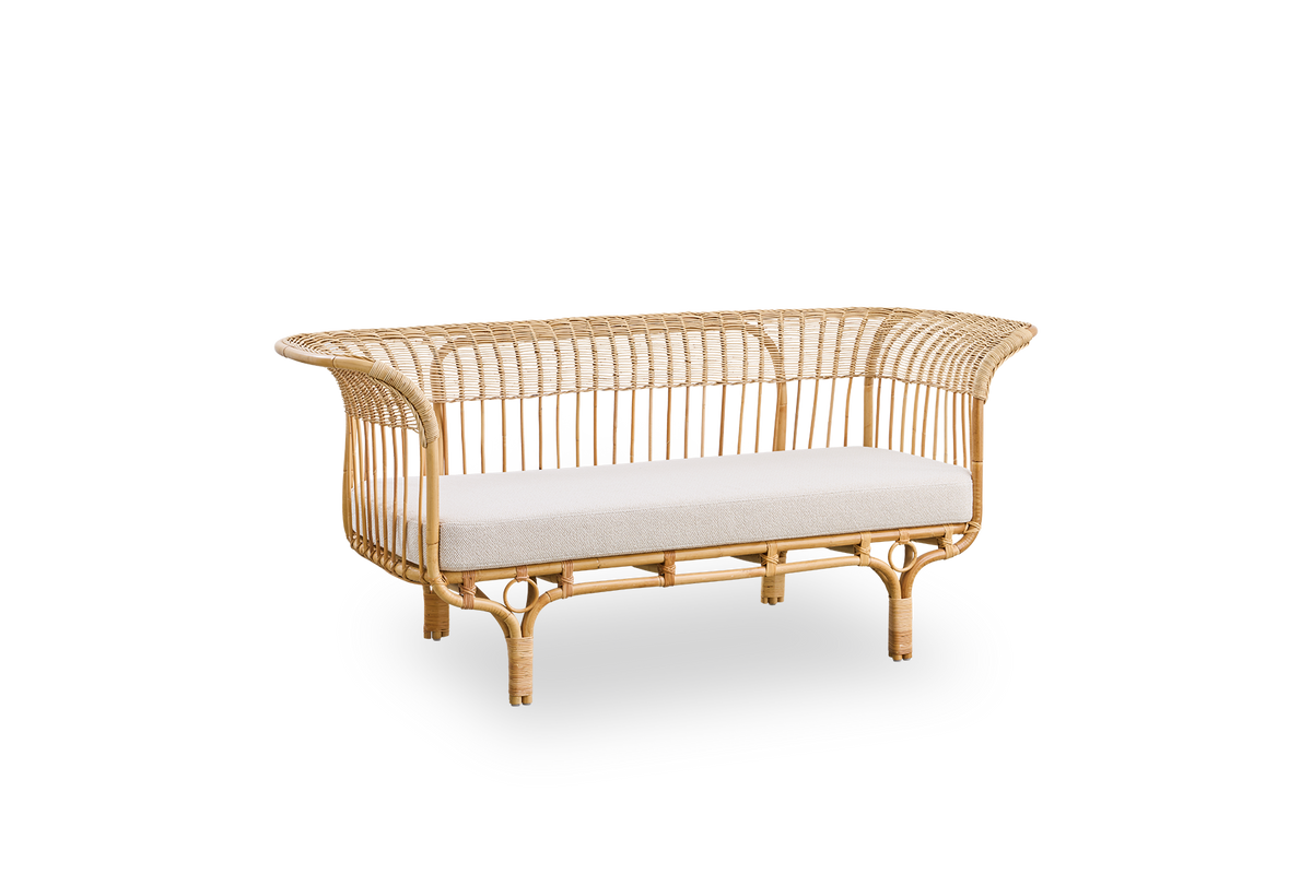 Side view of Belladonna sofa in natural rattan, designed by Franco Albini and Franca Helg. The sofa has an elegant expression with thin legs and a majestic seat with many detailed windings.