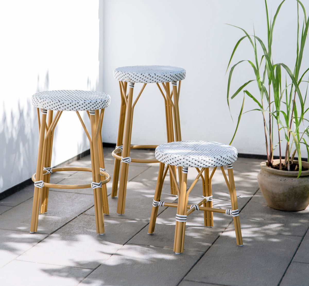 This is a lifestyle image of Simone Exterior Stool in almond aluminium frame white w cappuccino dot artfibre. Styled in a bright interior setting.