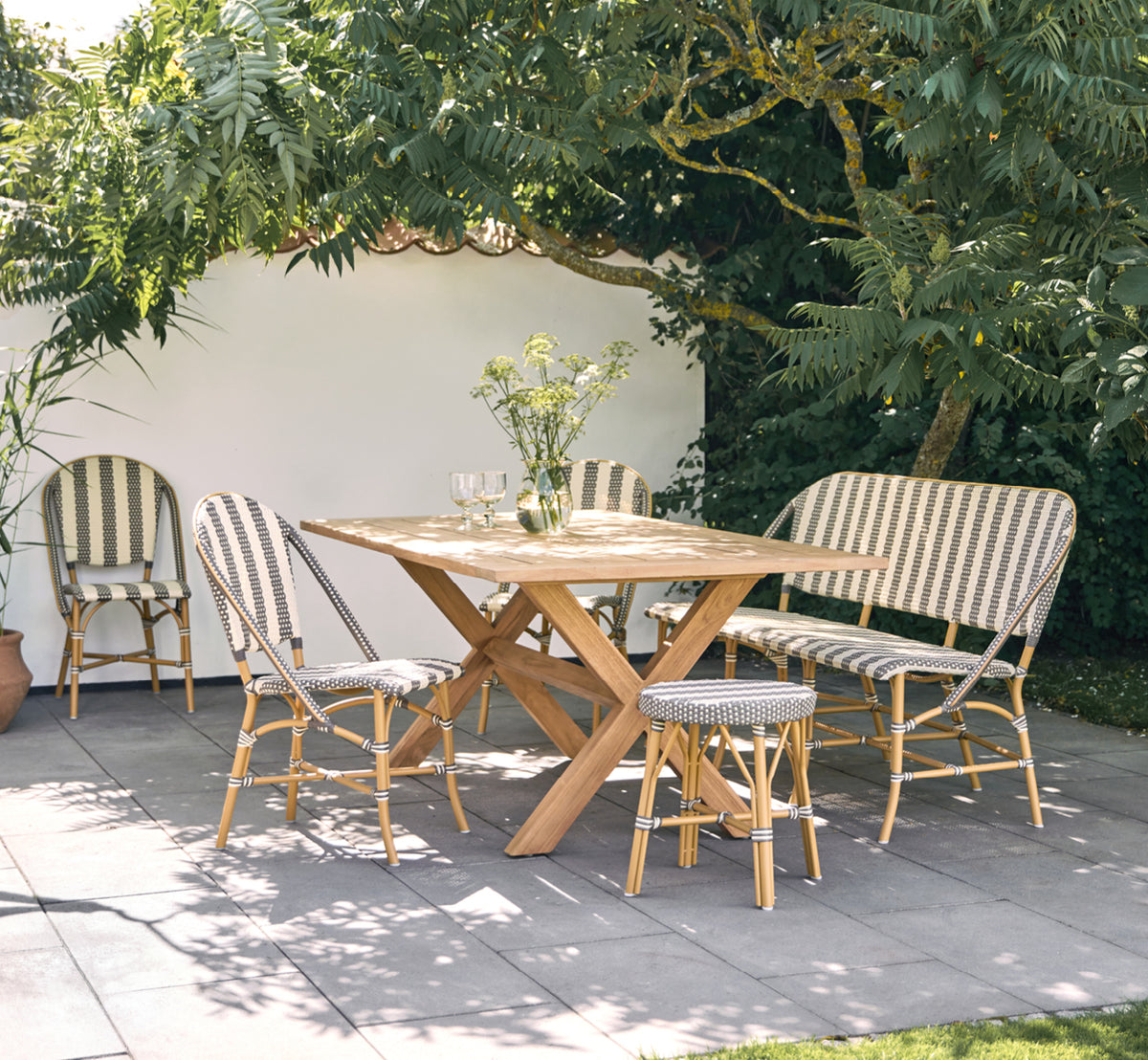 This is a lifestyle image of Sofie Exterior 3-Seater Bench in almond aluminium frame striped cappuccino ivory artfibre.