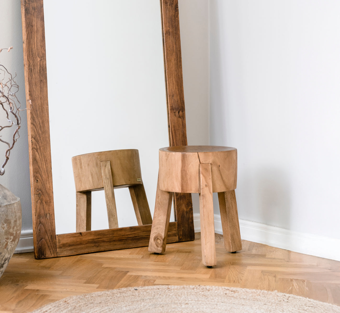 This is a lifestyle image of Roger Stool in teak indoor. Placed at a wooden desk with lamp and plant in a bright herringbone-floor study.