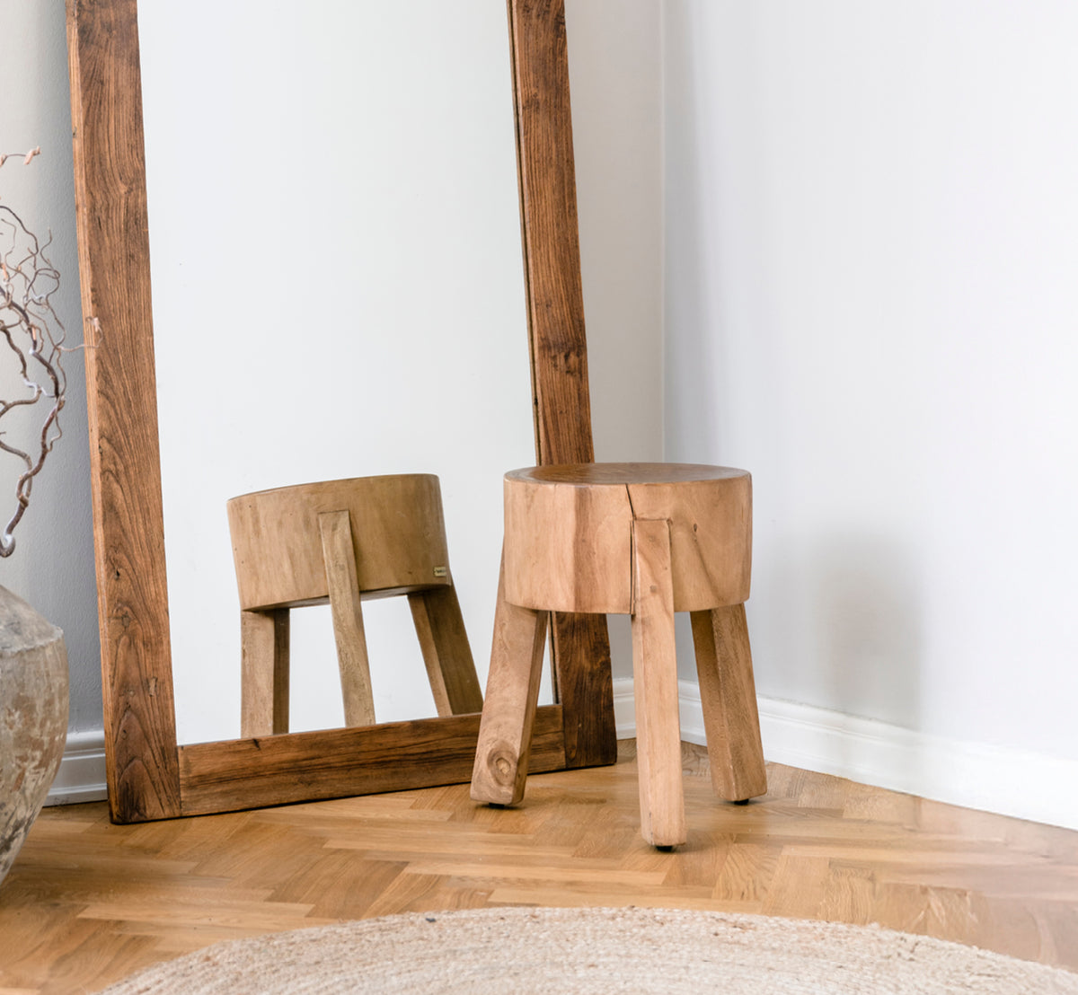 This is a lifestyle image of Roger Stool in teak indoor. Placed at a wooden desk with lamp and plant in a bright herringbone-floor study.