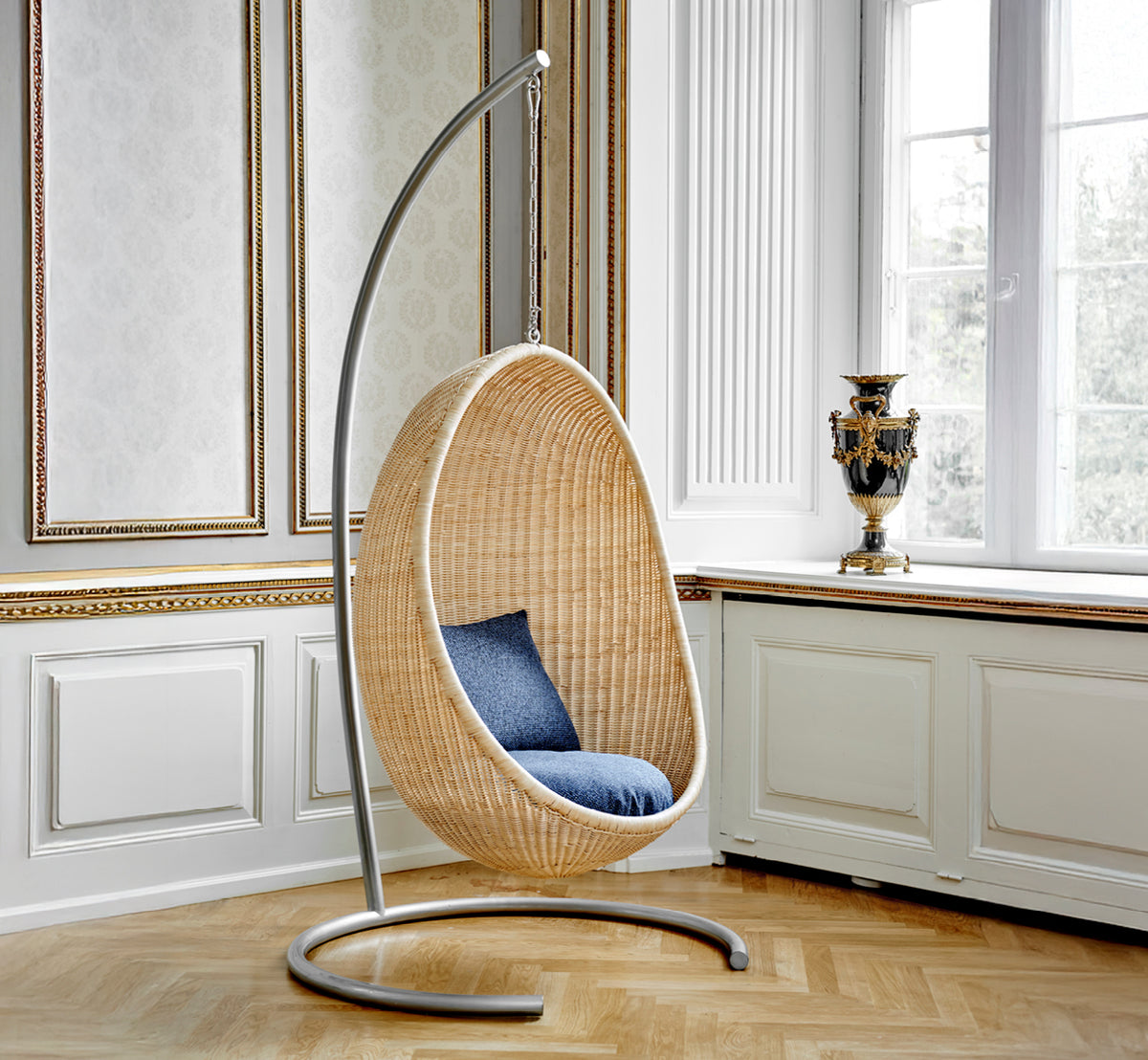 This is a lifestyle image of Stand Hanging Egg Chair in metal stand, in an elegant classical interior with ornate golden mouldings.