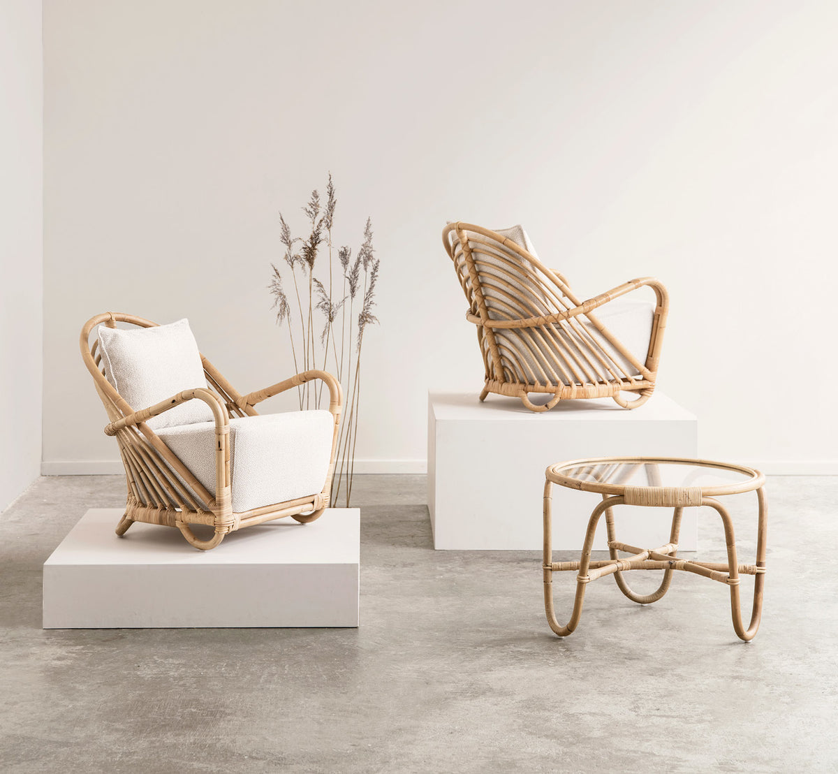 This is a lifestyle image of Charlottenborg Coffee Table in polished Natural Rattan, in an elegant classical interior with ornate golden mouldings.